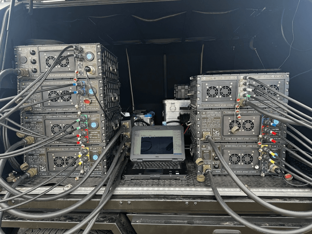 Two Defender modular jammers synchronized via Leo control software on a laptop — multi-unit coordinated deployment